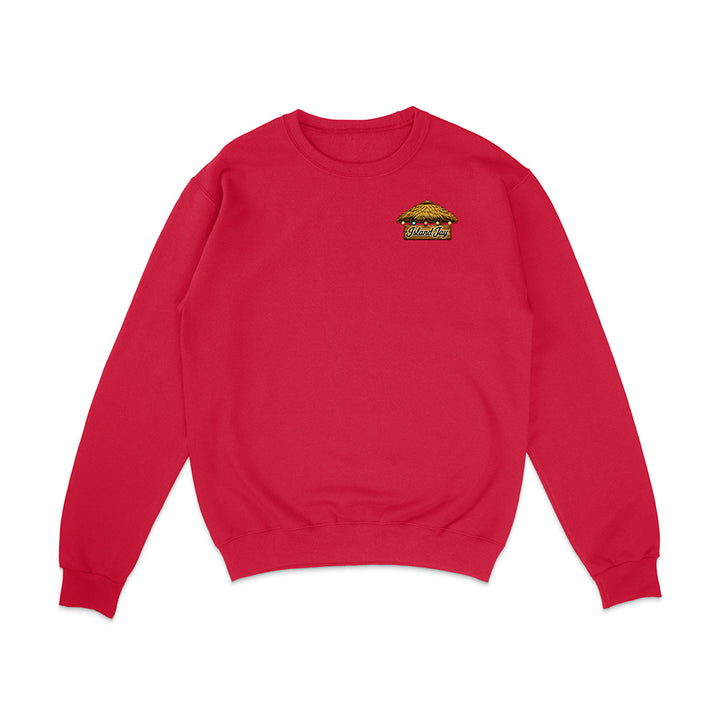 A red crewneck sweatshirt with a small embroidered graphic on the left chest depicting a taco with the word 'Tacos' below it, shown on a plain white background.