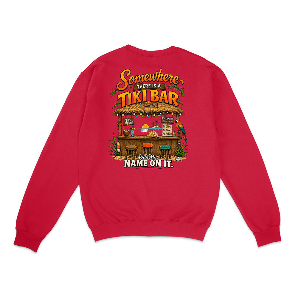 A red crewneck sweatshirt shown from the back, featuring a colorful graphic print of a tropical 'Tiki Bar' with the text 'Somewhere there is a TIKI BAR and my NAME ON IT.'.