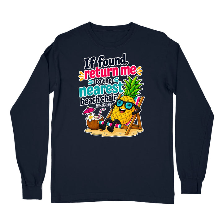 A navy blue long-sleeve t-shirt with a colorful graphic on the front. The graphic features a pineapple wearing sunglasses and a beach chair next to a coconut drink, with the text 'If found, return me to the nearest beach chair' in a playful multicolor font.