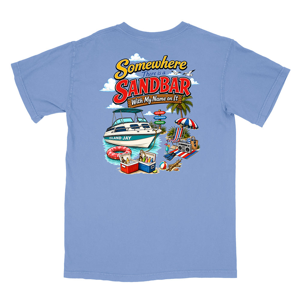 A light blue short-sleeve t-shirt with a colorful graphic print on the back. The graphic features the text 'Somewhere There is a SANDBAR With My Name on It' in a retro yellow and red font, above an illustration of a white motorboat on blue water, a beach umbrella, a cooler, and a beach chair.