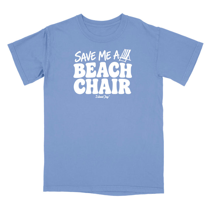 A light blue short-sleeve t-shirt with a bold white graphic on the chest reading 'SAVE ME A BEACH CHAIR' 