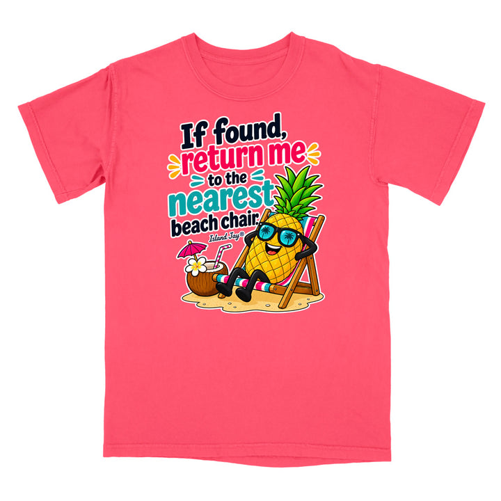 A bright pink short-sleeve t-shirt with a colorful graphic on the front. The graphic features a cartoon pineapple wearing sunglasses and relaxing in a beach chair next to a coconut drink, with the text 'If found, return me to the nearest beach chair' and 'Shut up and type in lowercase'.