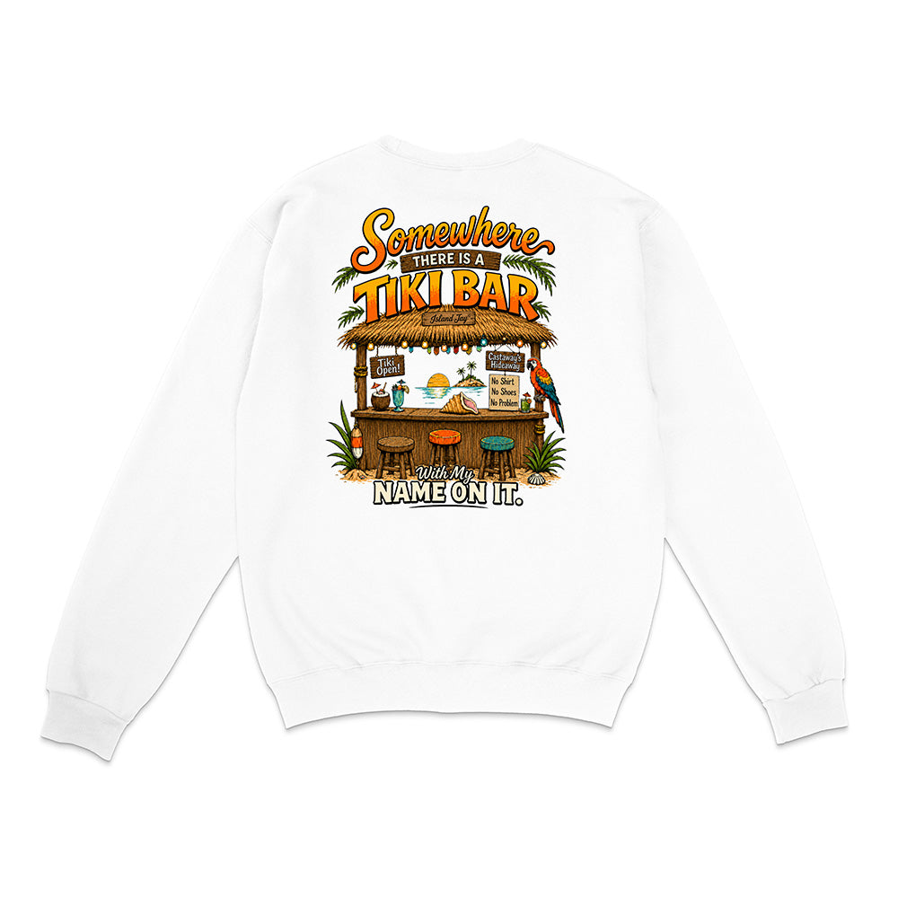 A white long-sleeve crewneck sweatshirt shown from the back, featuring a colorful graphic print of a tropical tiki bar with the text 'Somewhere There Is A TIKI BAR' and 'With My NAME ON IT.'.