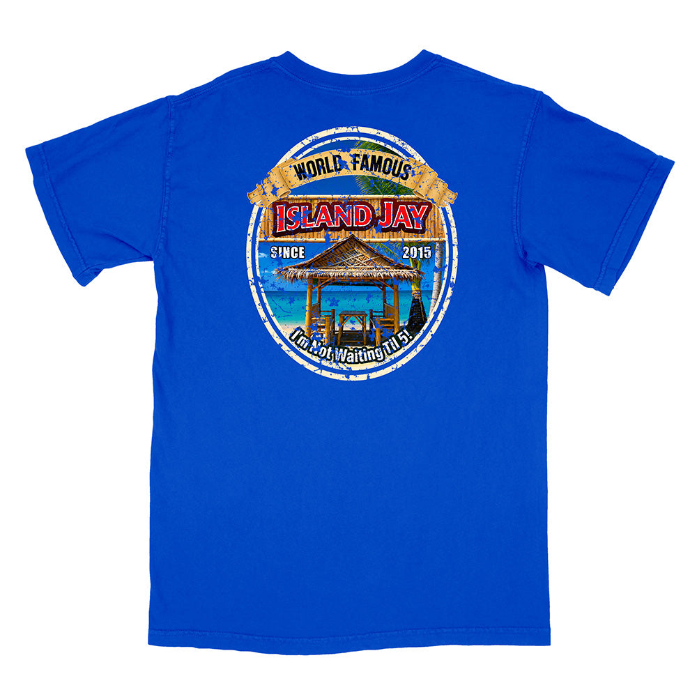 A royal blue short-sleeve t-shirt shown from the back, featuring a large circular graphic print on the center back with a beach hut, ocean, and text reading 'World Famous Island Jay' and 'I'm Not Waiting For You'.
