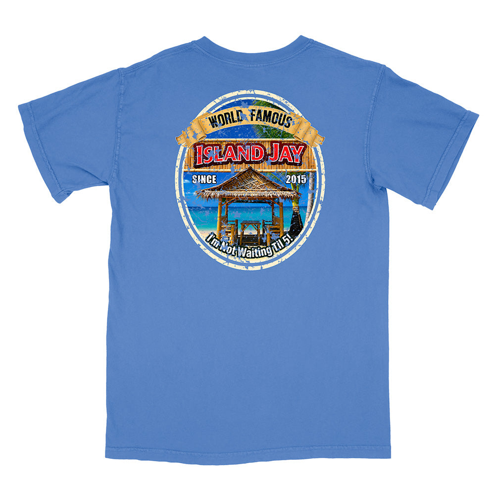 A blue short-sleeve t-shirt shown from the back, featuring a large circular graphic print on the center back with a beach cabana illustration and the text 'WORLD FAMOUS ISLAND JAY' and 'SINCE 2015'.