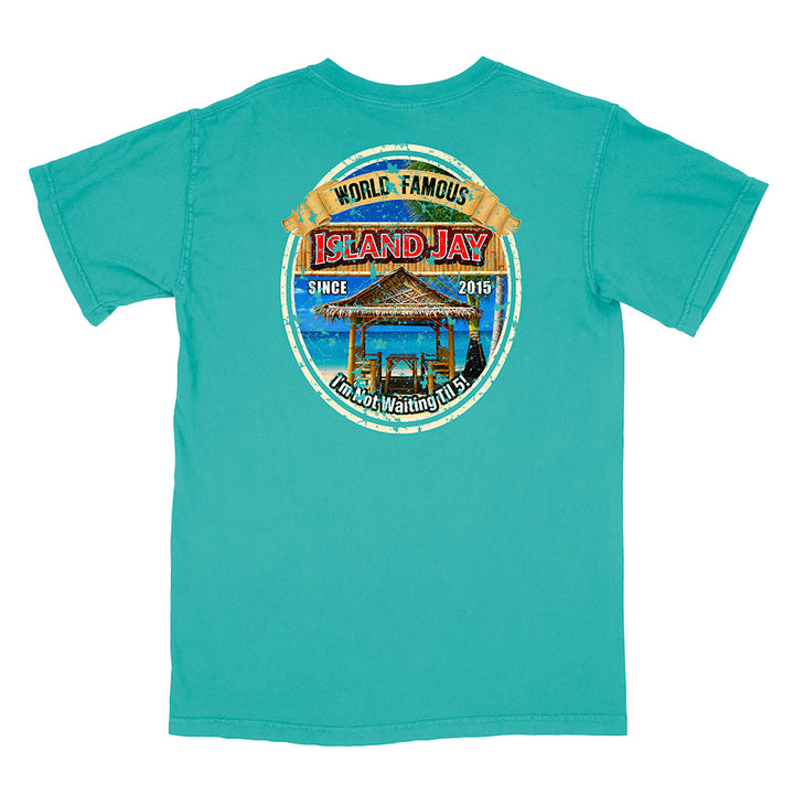 A turquoise short-sleeve t-shirt with a large circular graphic on the back. The graphic features a tropical beach scene with a thatched-roof gazebo, blue water, and a yellow banner reading 'WORLD FAMOUS ISLAND JAY'.