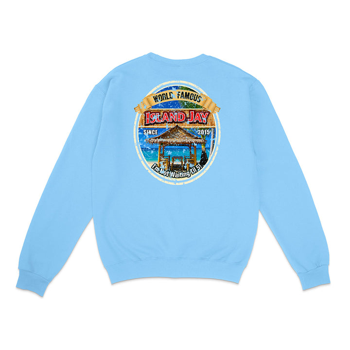A light blue crewneck sweatshirt shown from the back, featuring a large circular graphic print on the center back with a beach cabana, palm trees, and the text 'Island Hay' and 'While Famous'.