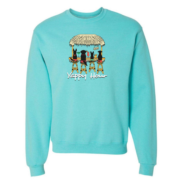 Turquoise sweatshirt with a graphic of dogs around a table under a thatched roof and 'Yappy Hour' text.
