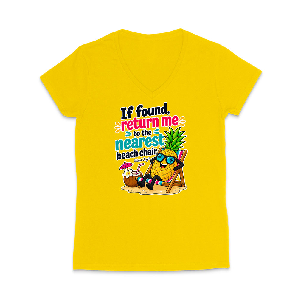 A bright yellow women's V-neck t-shirt with a colorful graphic on the front. The graphic features a cartoon pineapple wearing sunglasses and sitting in a wooden beach chair next to a coconut drink with a pink umbrella, with the text 'If found, return me to the nearest beach chair' in black, pink, and blue lettering.
