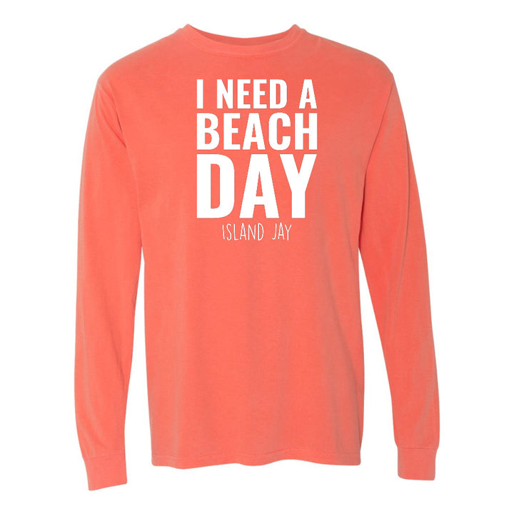 Coral long-sleeve shirt with 'I NEED A BEACH DAY' text on a white background