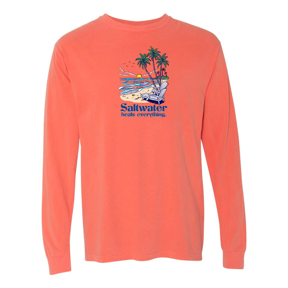 Coral long-sleeve shirt with a beach graphic and 'Saltwater heals everything' text on a white background
