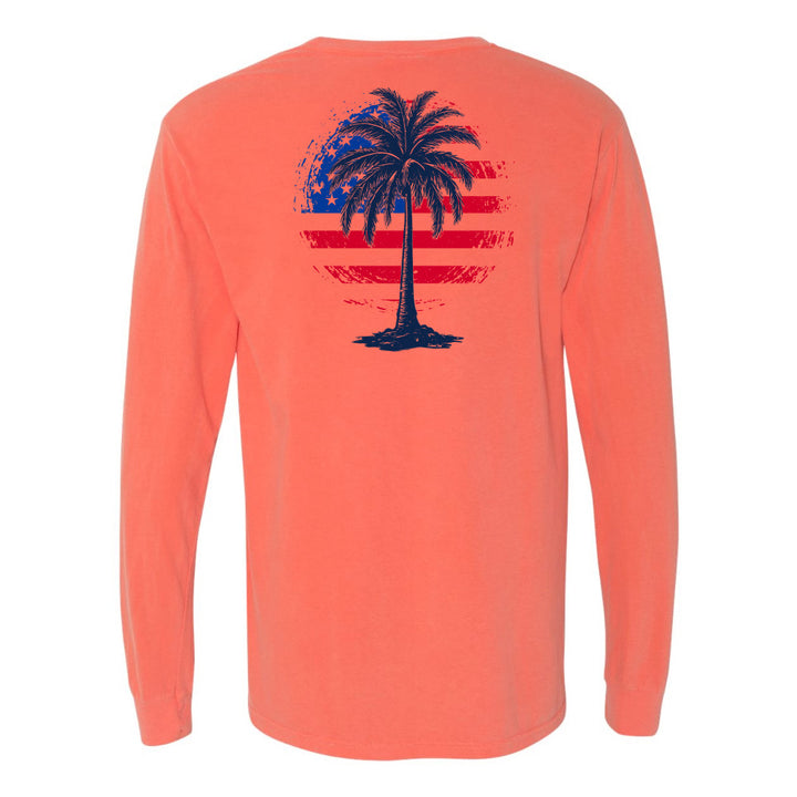 Coral long-sleeve shirt with a palm tree and American flag design on the back, against a white background.