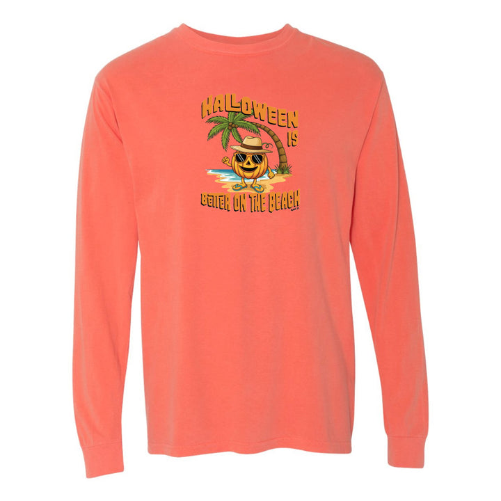 Coral long-sleeve shirt with Halloween design featuring a pumpkin on a beach.