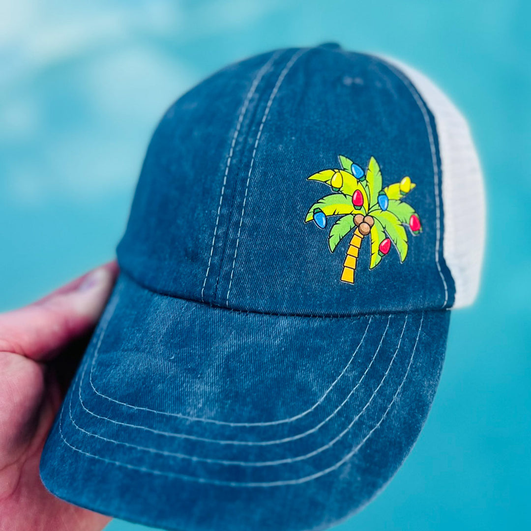 Deck The Palms Holiday Hat. Has a palm tree with Christmas lights. Navy