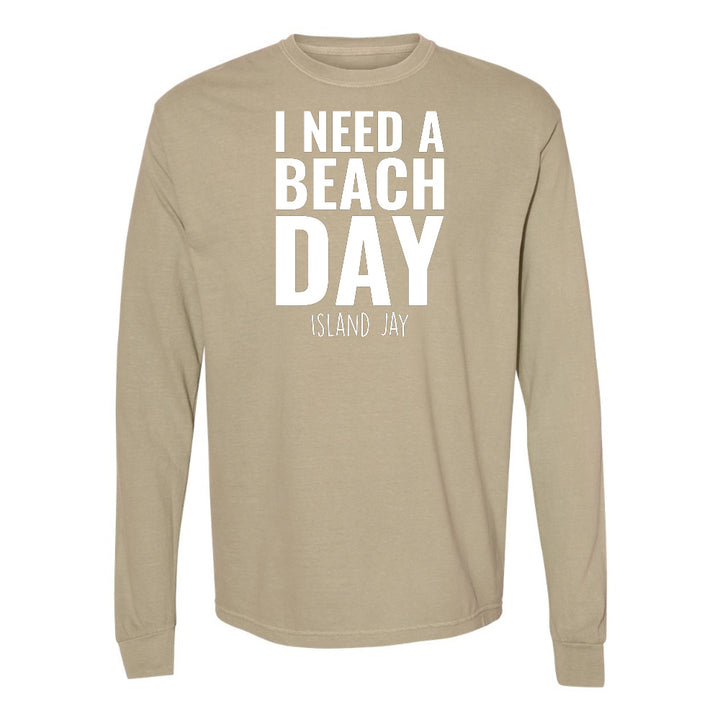 Beige long-sleeve shirt with 'I NEED A BEACH DAY' text on a white background