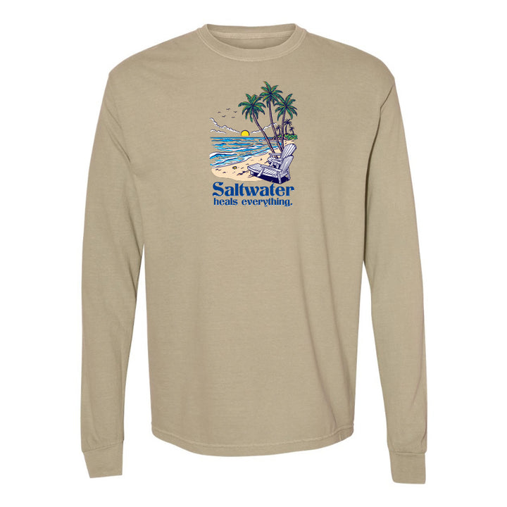Beige long-sleeve shirt with a beach graphic and 'Saltwater heals everything' text on a white background