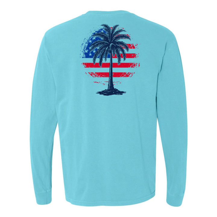 Light blue long-sleeve shirt with a palm tree and American flag design on the back against a white background.