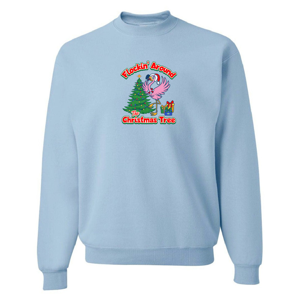 Light blue sweatshirt with Christmas-themed design featuring a flamingo and tree on a white background