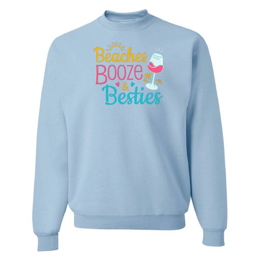 Light blue sweatshirt with 'Beaches Booze & Besties' text and wine glass graphic on a white background