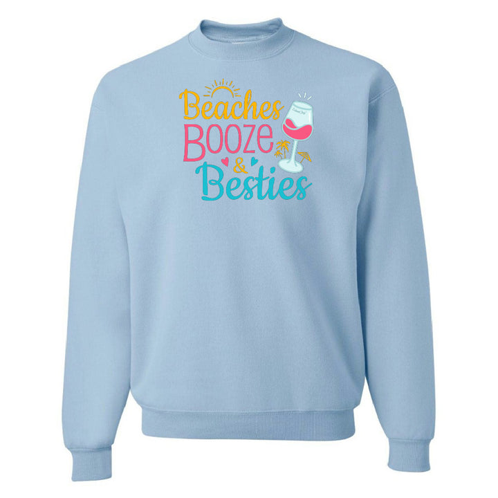 Light blue sweatshirt with 'Beaches Booze & Besties' text and wine glass graphic on a white background