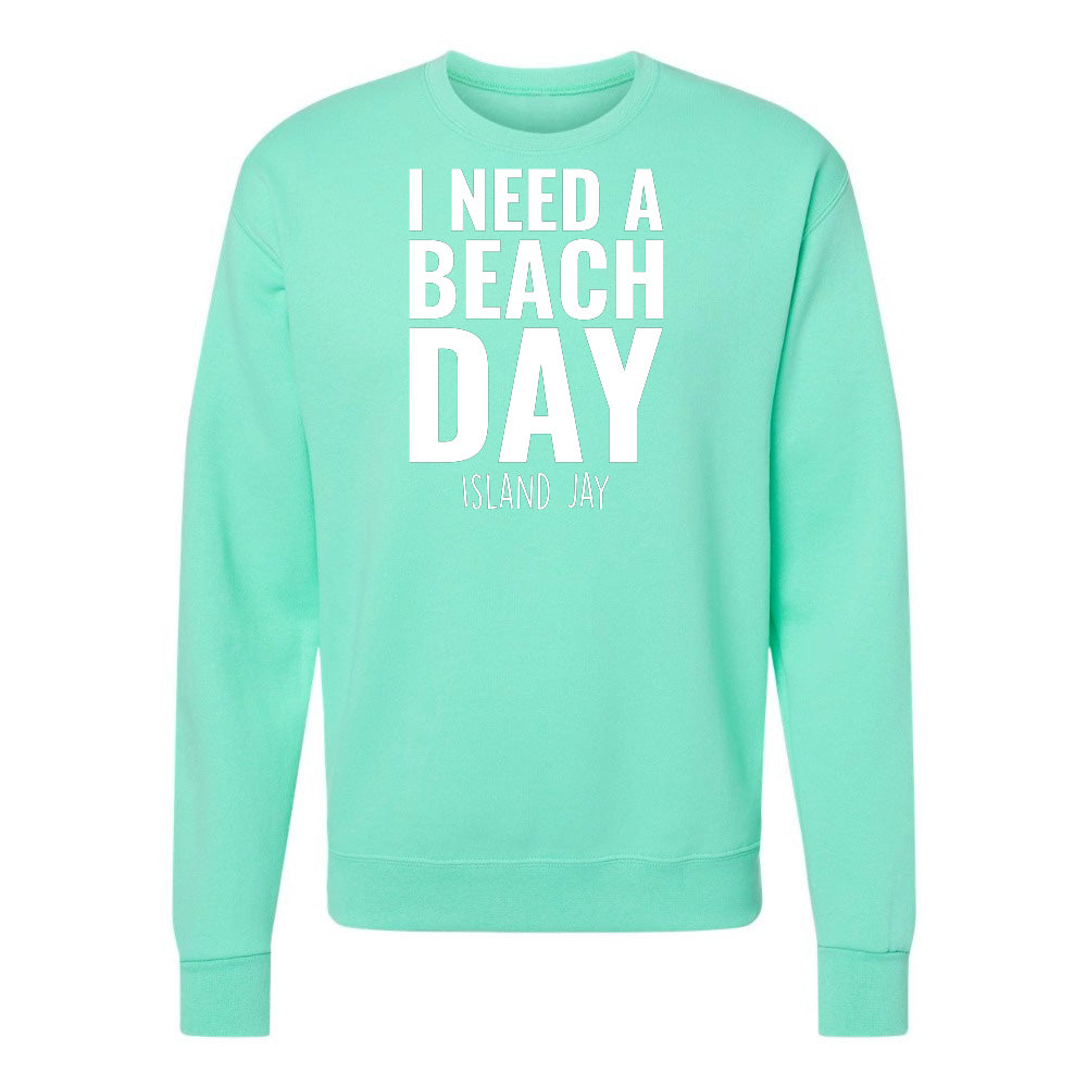 Mint green sweatshirt with 'I NEED A BEACH DAY' text on a white background