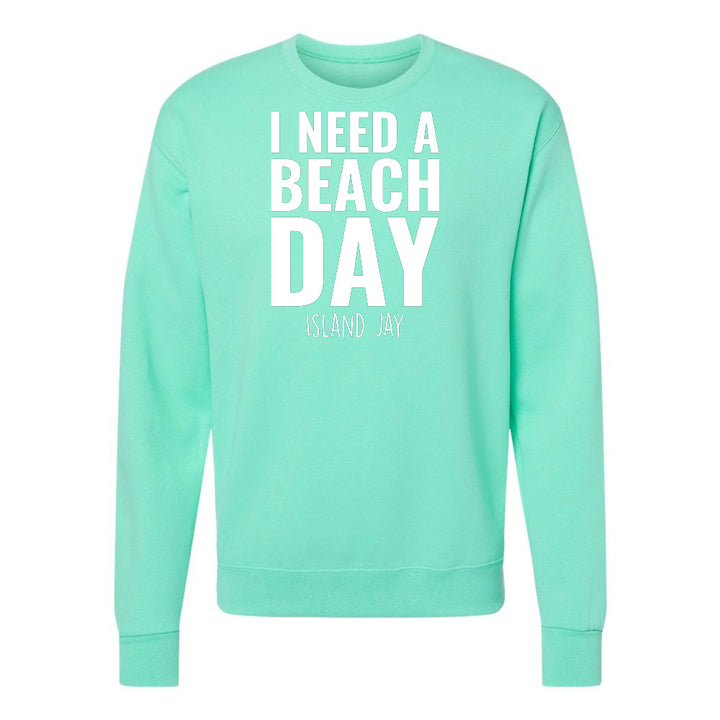 Mint green sweatshirt with 'I NEED A BEACH DAY' text on a white background