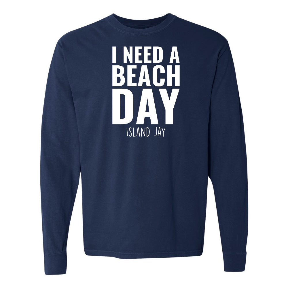 Navy blue long-sleeve shirt with 'I NEED A BEACH DAY' text on a white background