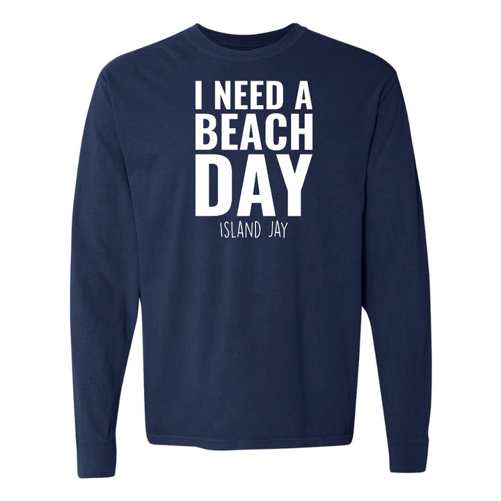 Navy blue long-sleeve shirt with 'I NEED A BEACH DAY' text on a white background