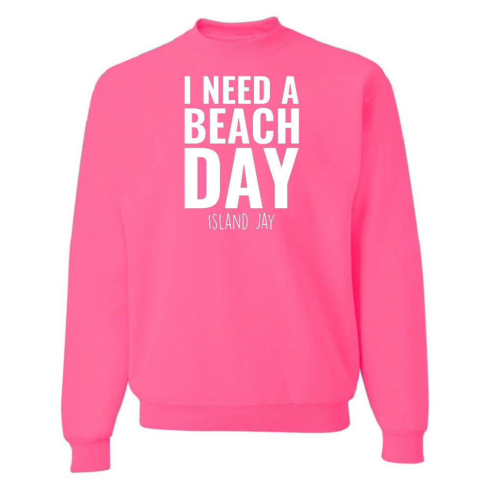 Pink sweatshirt with 'I NEED A BEACH DAY' text on a white background