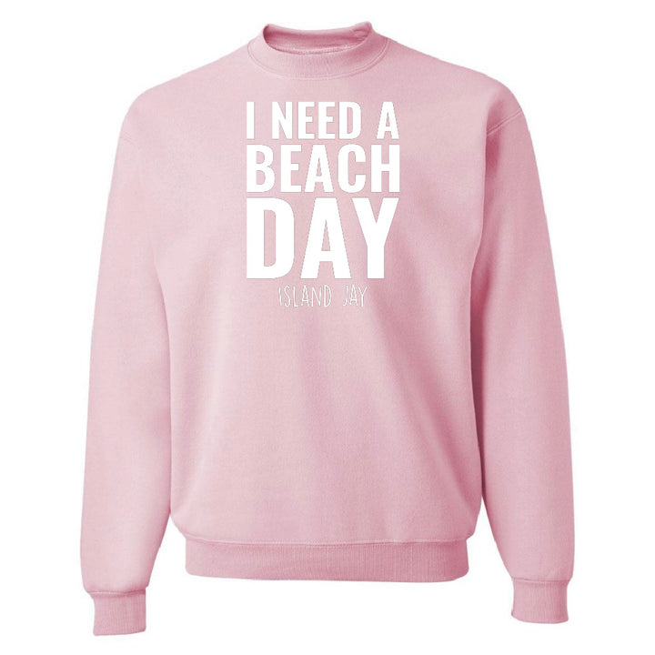 Pink sweatshirt with 'I NEED A BEACH DAY' text on a white background
