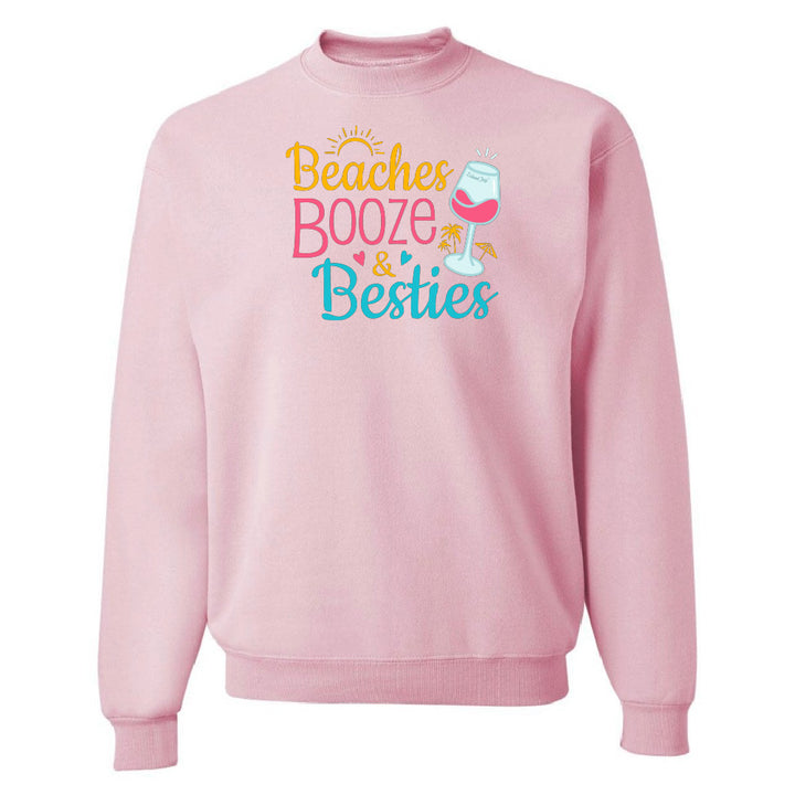 Pink sweatshirt with 'Beaches Booze & Besties' text and graphics on a white background