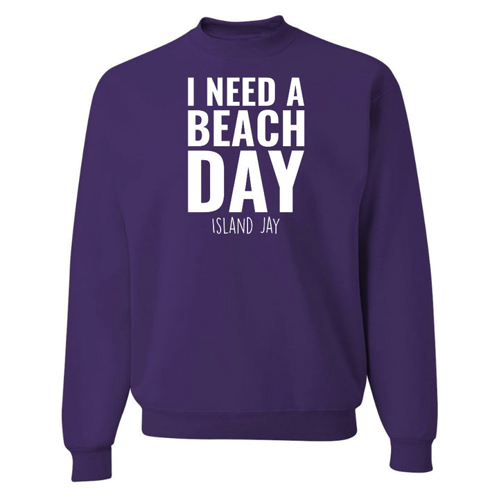 Purple sweatshirt with 'I NEED A BEACH DAY' text on a white background