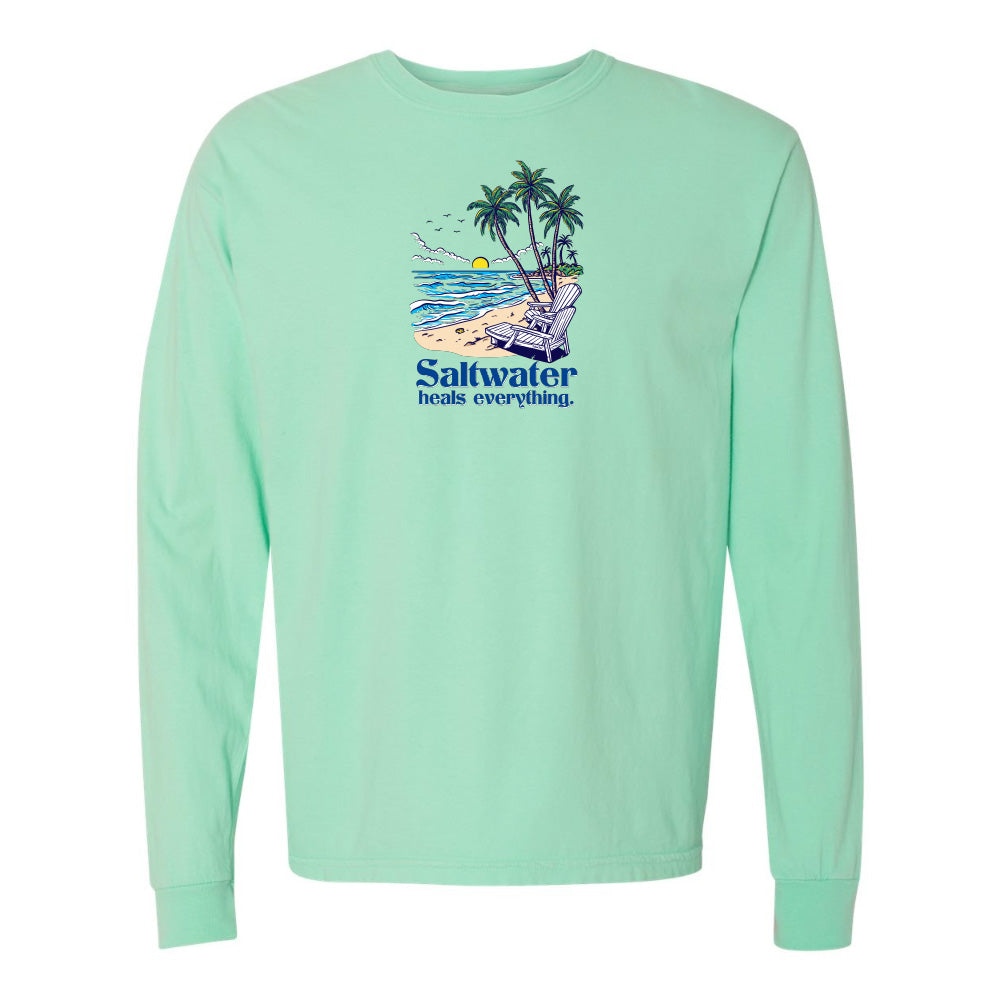 Mint green long-sleeve shirt with a beach graphic and 'Saltwater heals everything' text on a white background.