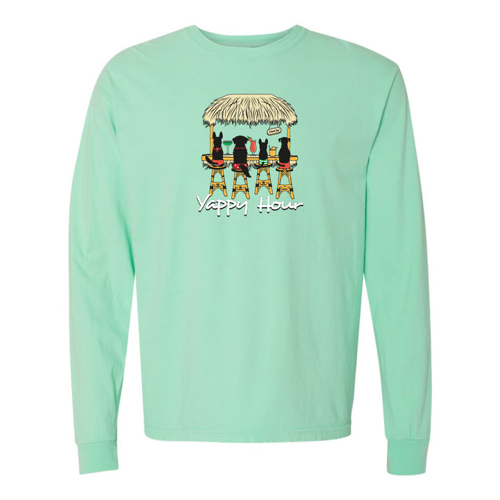 Mint green long-sleeve shirt with a graphic of dogs at a bar and 'Yappy Hour' text on a white background.