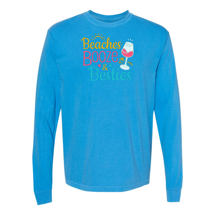 Blue long-sleeve shirt with 'Beaches Booze & Besties' text and wine glass graphic on a white background