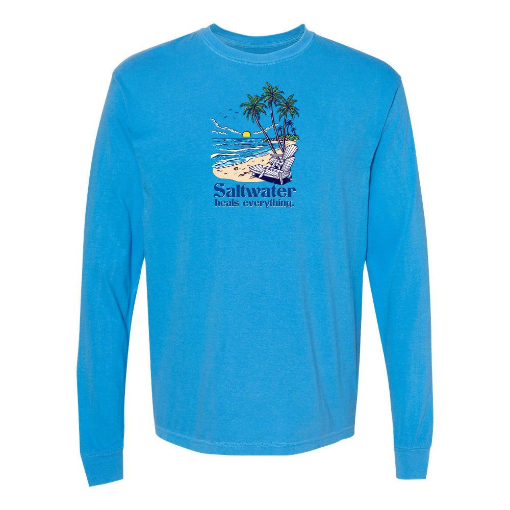 Blue long-sleeve shirt with a beach graphic and 'Saltwater heals everything' text on a white background