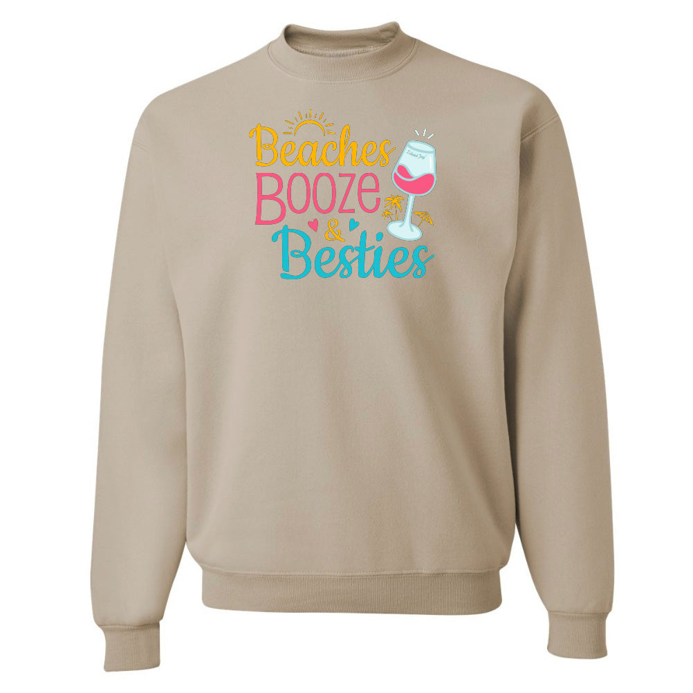 Beige sweatshirt with 'Beaches Booze & Besties' text and wine glass graphic on a white background