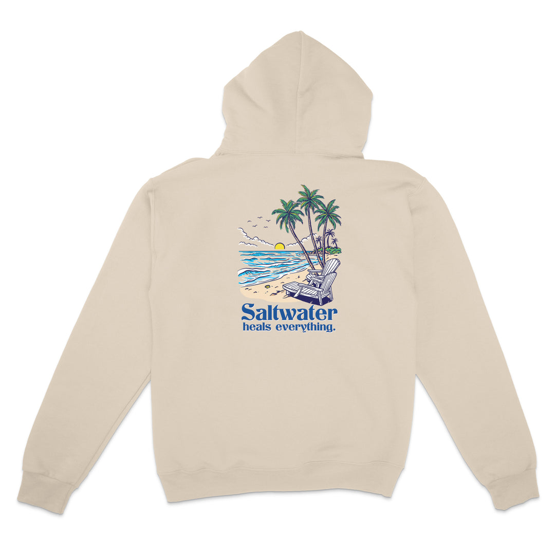 Beige hoodie with a beach graphic and 'Saltwater heals everything' text on the back, on a white background.