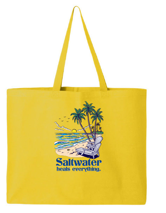 Yellow tote bag with a beach scene and 'Saltwater heals everything' text on a white background