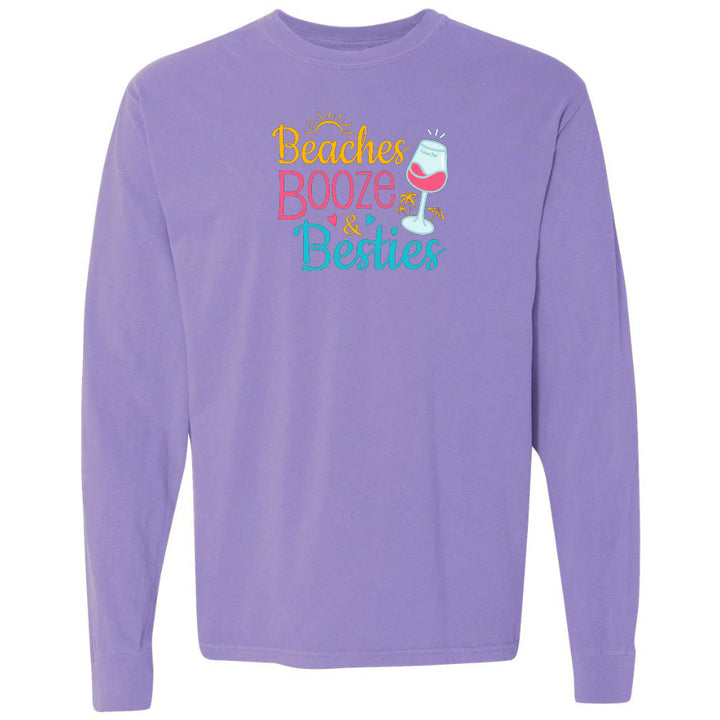 Purple long-sleeve shirt with 'Beaches Booze & Besties' text and wine glass graphic on a white background