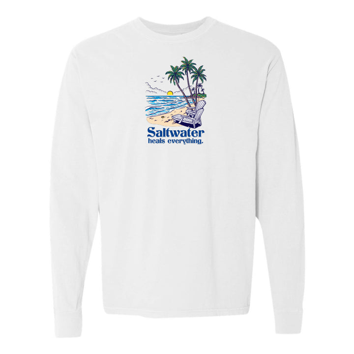 White long-sleeve shirt with a beach graphic and 'Saltwater heals everything' text on a white background